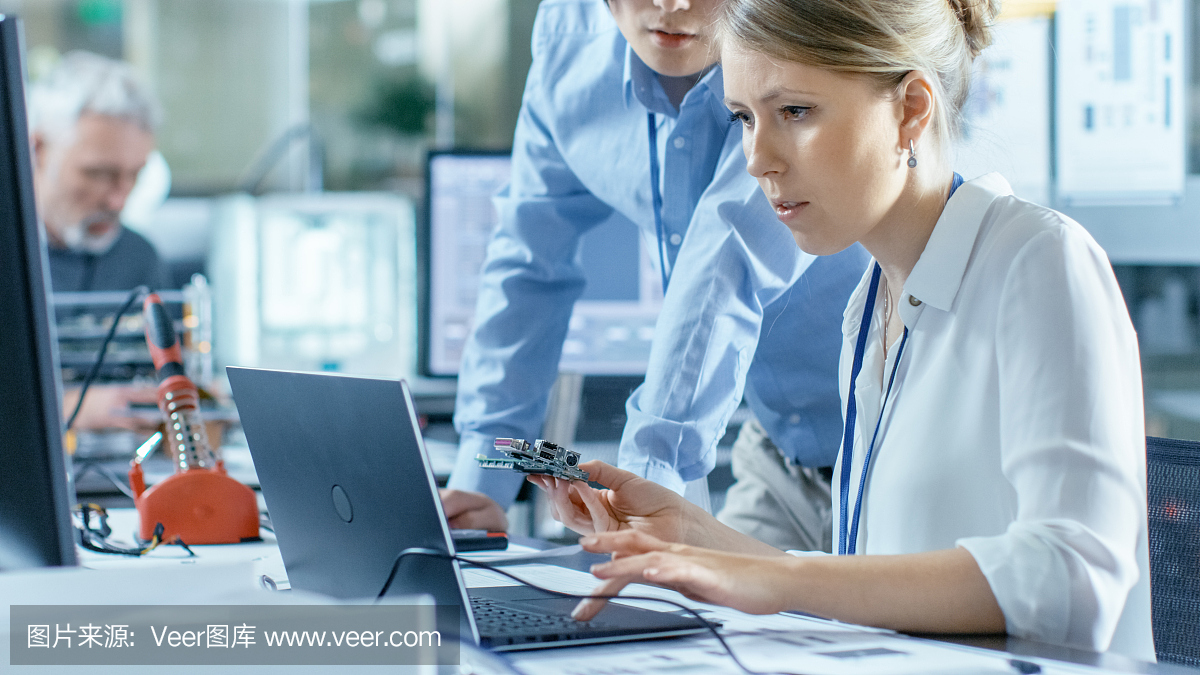 女計算機科學家將電路板連接到她的筆記本電腦并開始編程。她在先進技術(shù)實驗室工作。